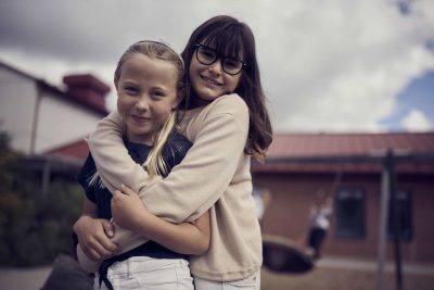 Två elever på Montessori Mondial står utanför skolan tillsammans.