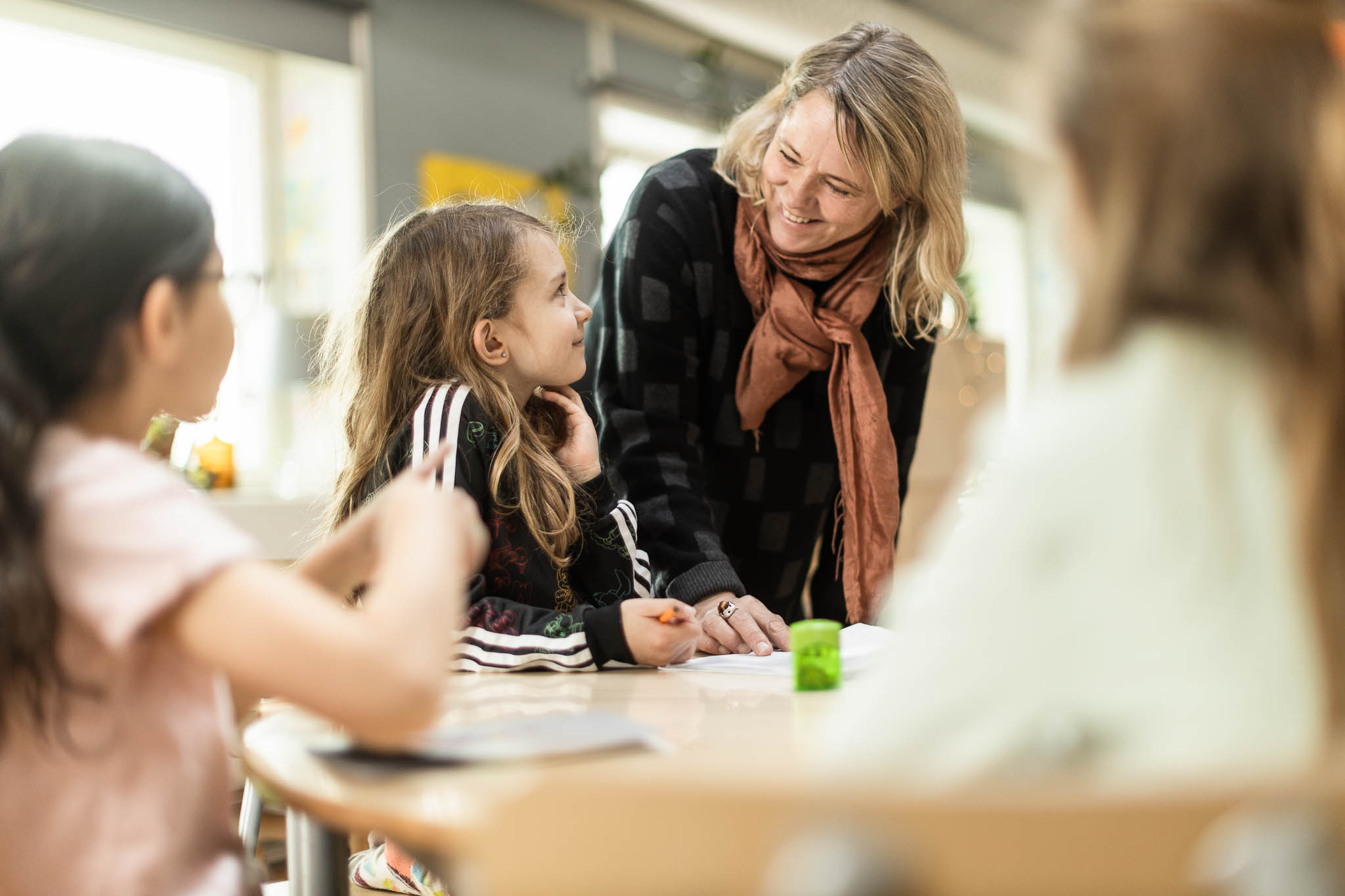 Pedagog står och hjälper elever med skolarbete