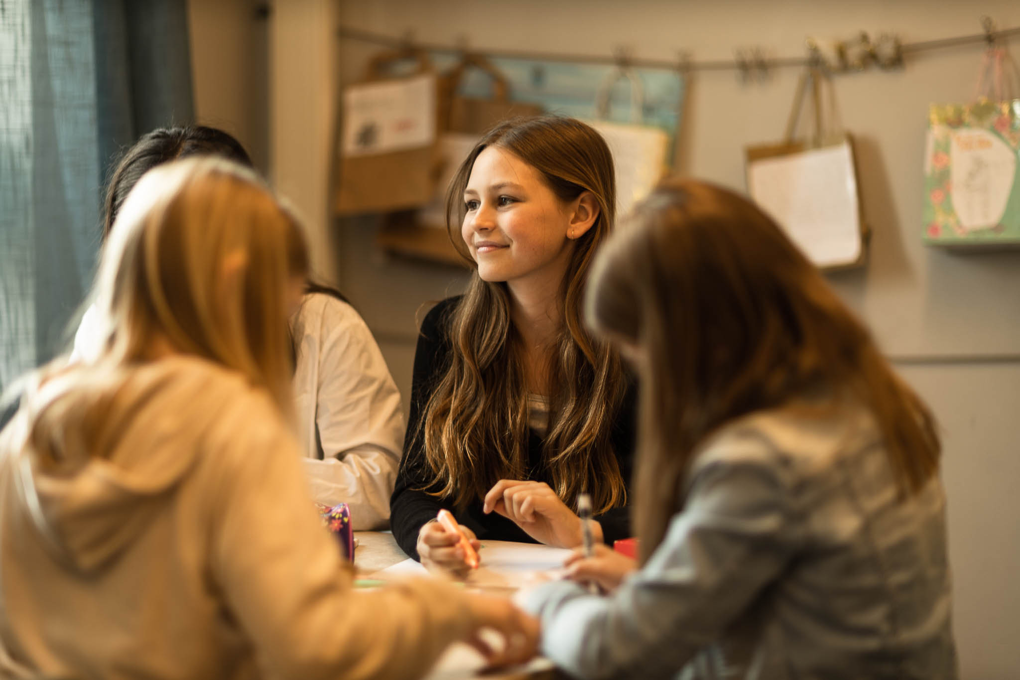 Fyra elever sitter vid ett bord och gör skolarbete