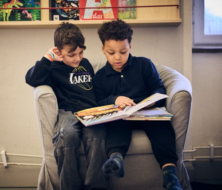 Två elever i förskoleklass läser tillsammans.