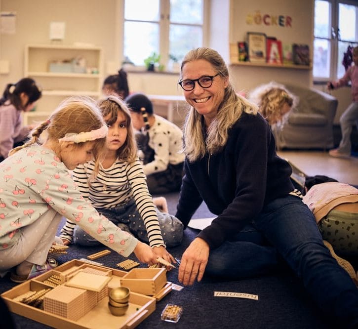 Elever sitter på golvet och lär med en pedagog.