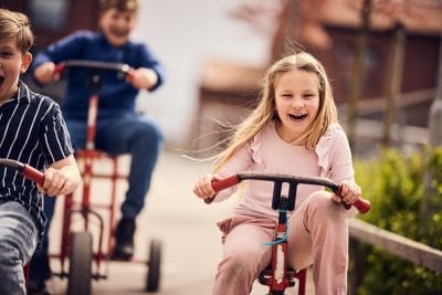Lågstadieelev på Mondial cyklar på skolgården.