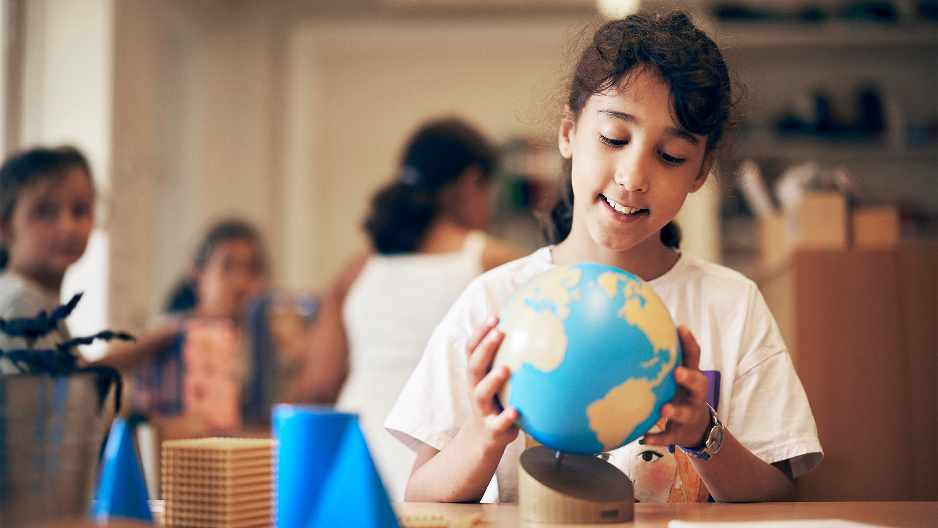 Elev i ett klassrum på Montessori Mondial som studerar en jordglob