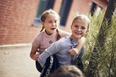 Två elever på Montessori Mondial Lund leker ute på skolgården.