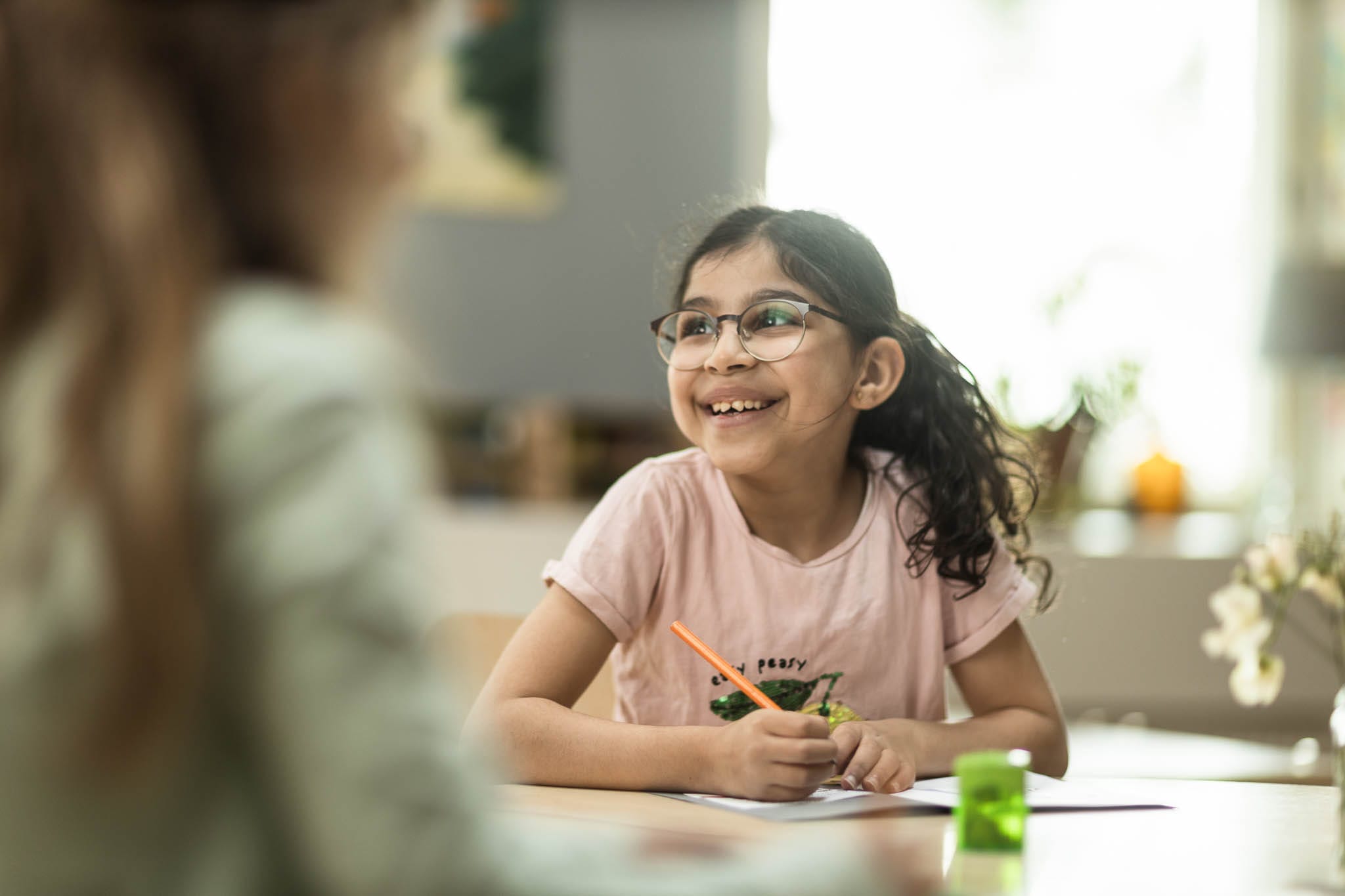 Elev sitter vid skrivbord med en penna i handen.