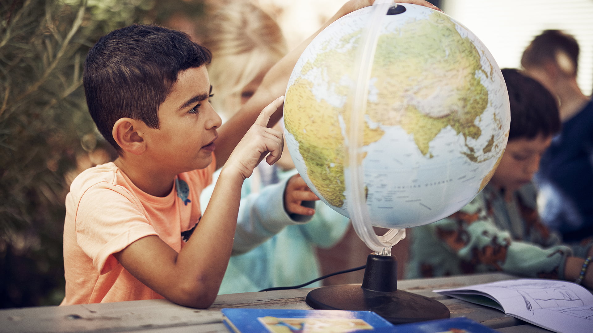 Elev på Montessori Mondial som pekar på en jordglob