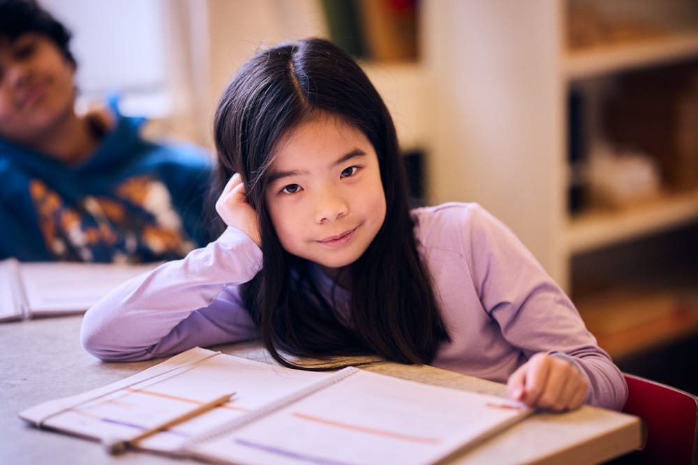 Elev på mellanstadiet sitter vid skolbänk.