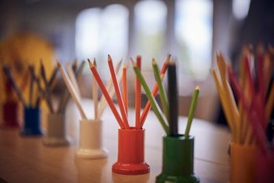 Färgglada pennor på ett skrivbord i klassrummet på Montessori Mondial.